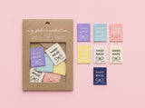 A craft kit package labeled 'my fabric addiction' next to several small fabric swatches in pastel colors, all arranged on a soft pink background.